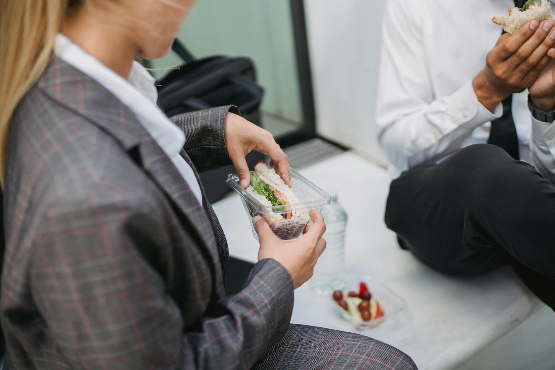 Pracownicy biurowi jedzą kanapki podczas przerwy na lunch